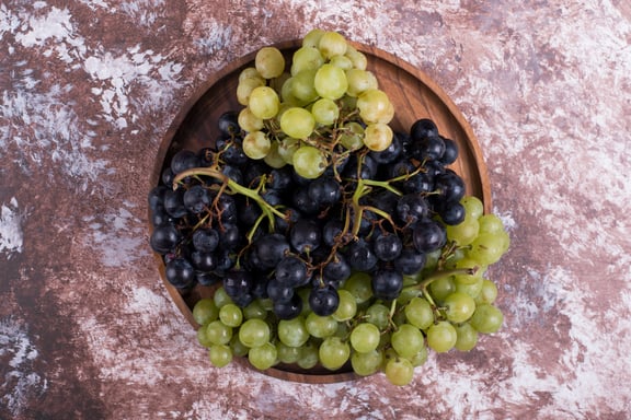 bunch-green-red-grapes-wooden-platter